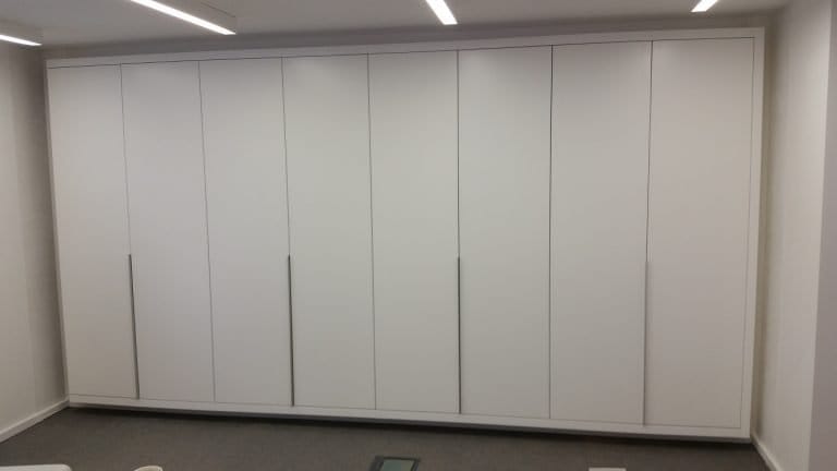 Run of white floor to ceiling fitted wardrobe doors