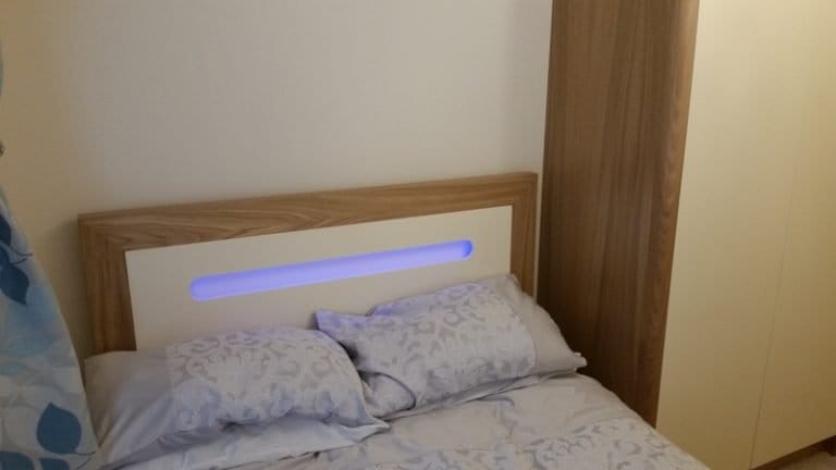 Fitted bedroom with a timber headboard and LED strip