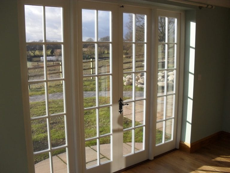 White glazed doors with a garden view through small panes
