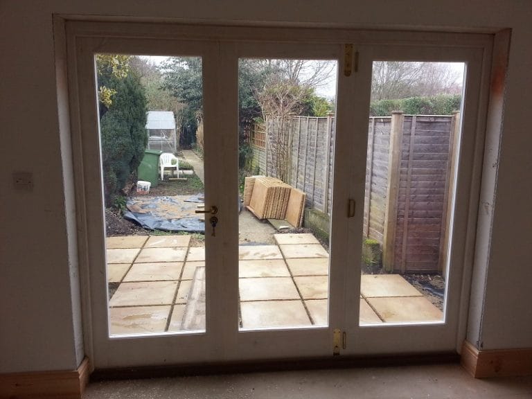 Timber glazed doors opening onto a paved courtyard