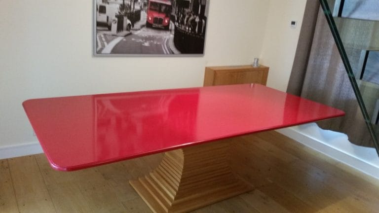 Glossy red dining table with a timber base