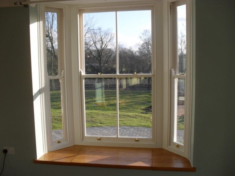 White timber bay window looking onto a lawn