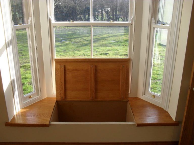 Timber bay window above a built in panelled window seat
