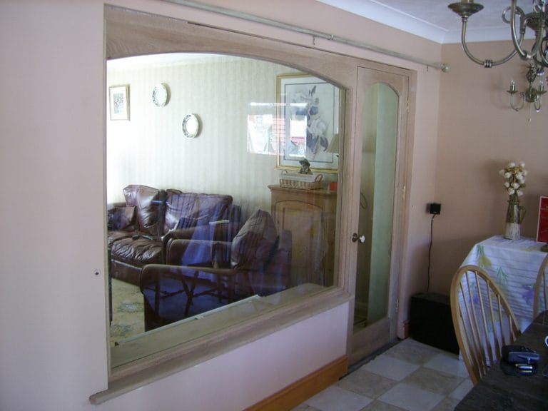Timber window through to a living room with a tartan sofa