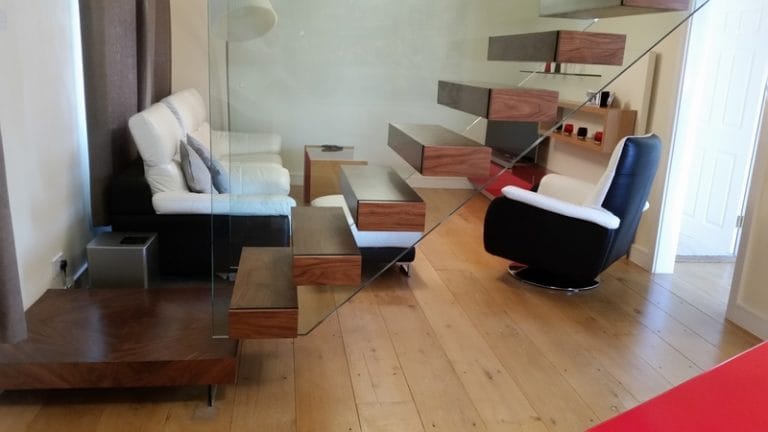 Floating staircase above a living room with modern furniture