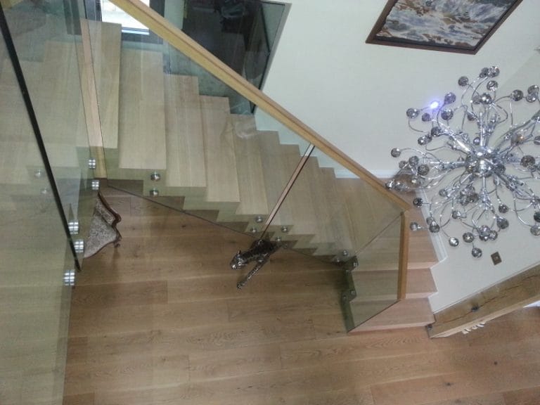 Floating timber staircase with glass balustrade and a feature light