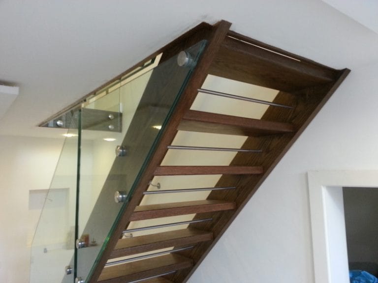 Dark timber open tread staircase with glass balustrade
