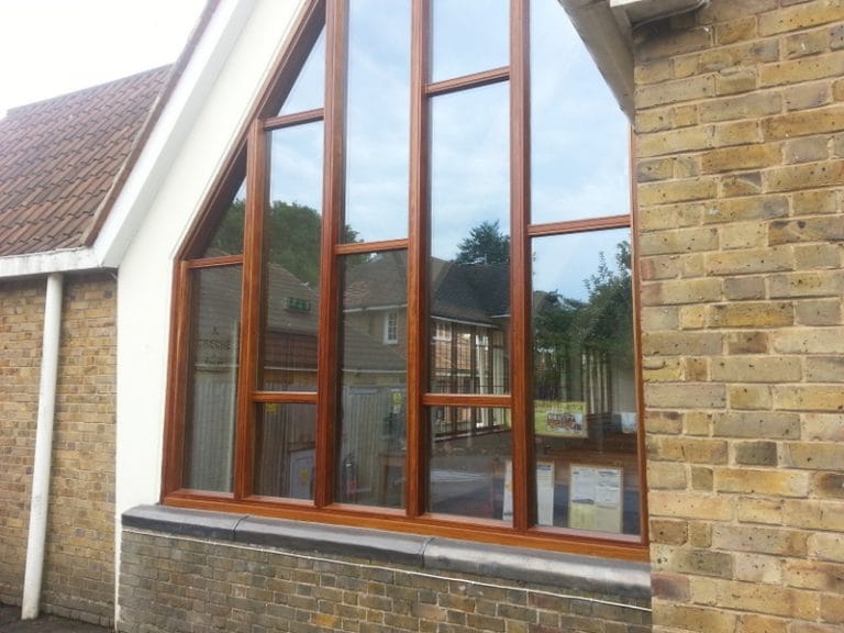 Natural timber glazing in the gable of a brick church