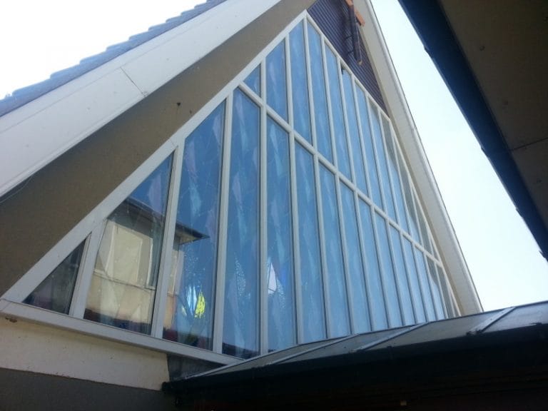 Looking up at a tall timber glazed church window
