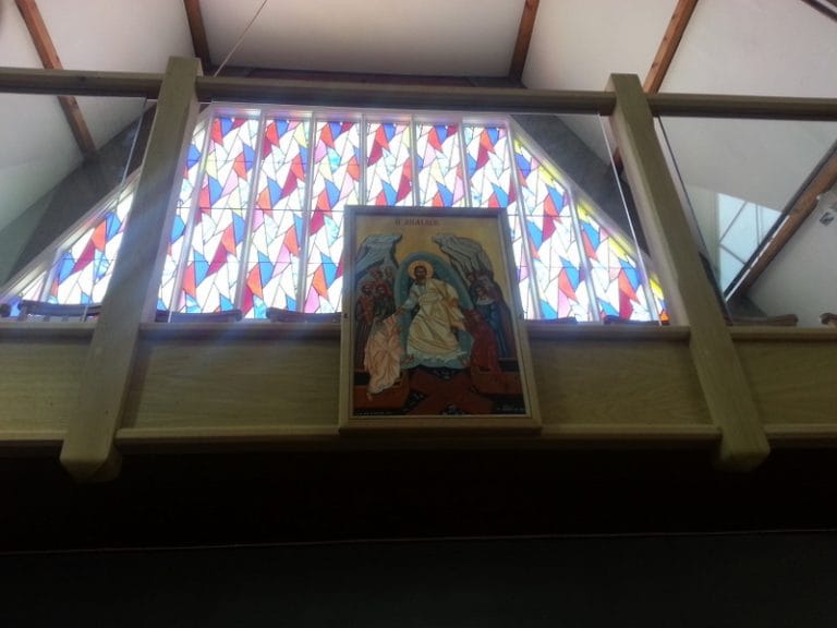 Timber gallery front below a colourful stained glass window