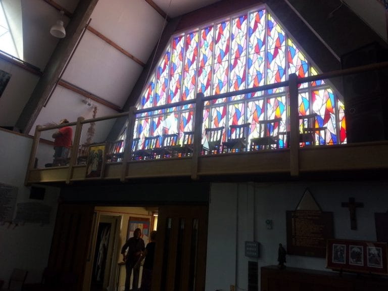 Church gallery balustrade in timber below stained glass