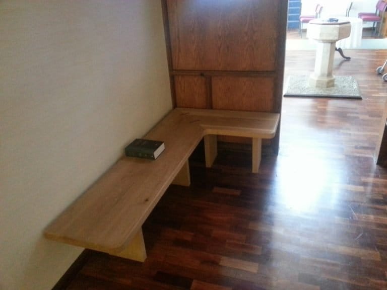 Timber corner bench with a book on a dark wood floor