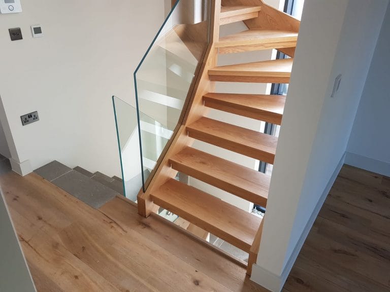 Open riser timber staircase with a glass balustrade