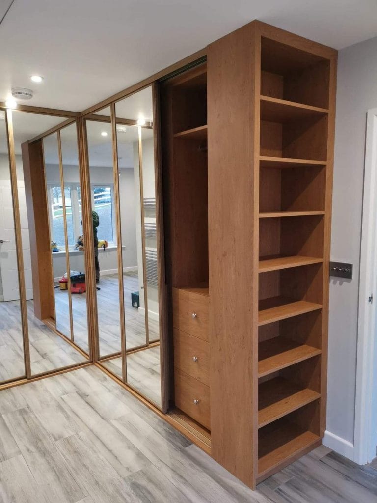 Fitted mirrored wardrobe doors and open timber shelving