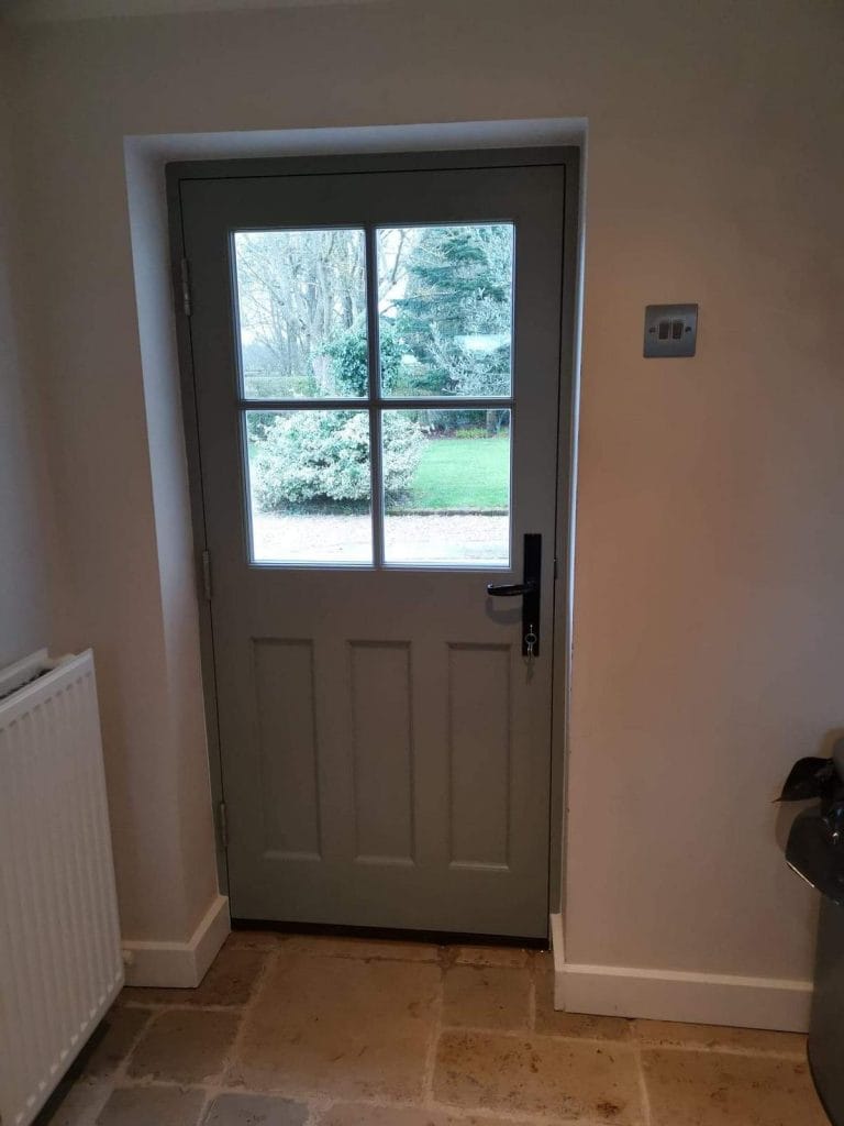 Half glazed painted door seen from inside a hallway