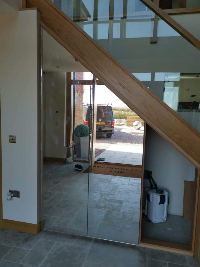 Glazed screen with a timber staircase in a hallway