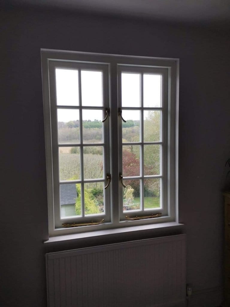 White timber window with glazing bars, viewed from a dark room