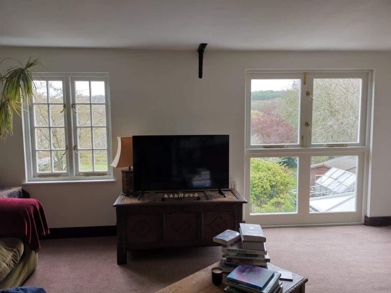 White timber windows in a living room with a garden beyond