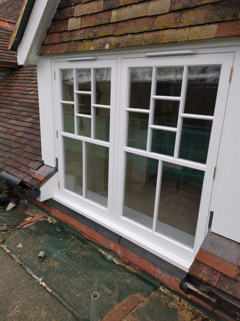 White timber casement window with glazing bars, opened outwards