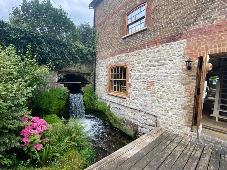 Natural timber window in a stone mill building beside a stream