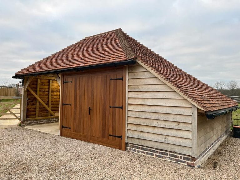 Weatherboarded timber garage with natural wood double doors