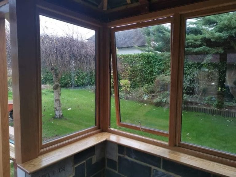 Timber framed corner windows looking out over a garden