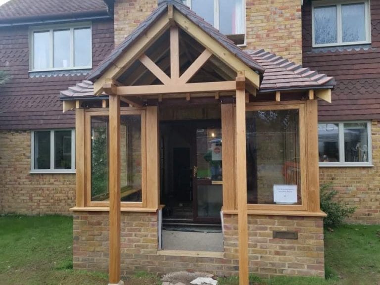 Timber framed porch with glazed sides on a brick house