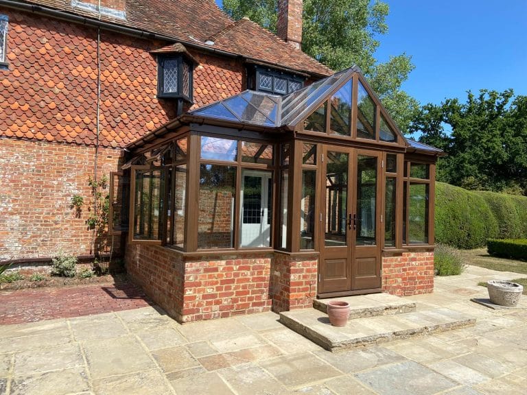 Hardwood conservatory with glazed gable on a red brick home