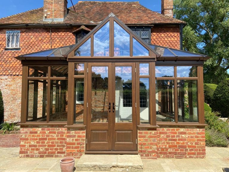 Timber conservatory with a gabled front and central double doors