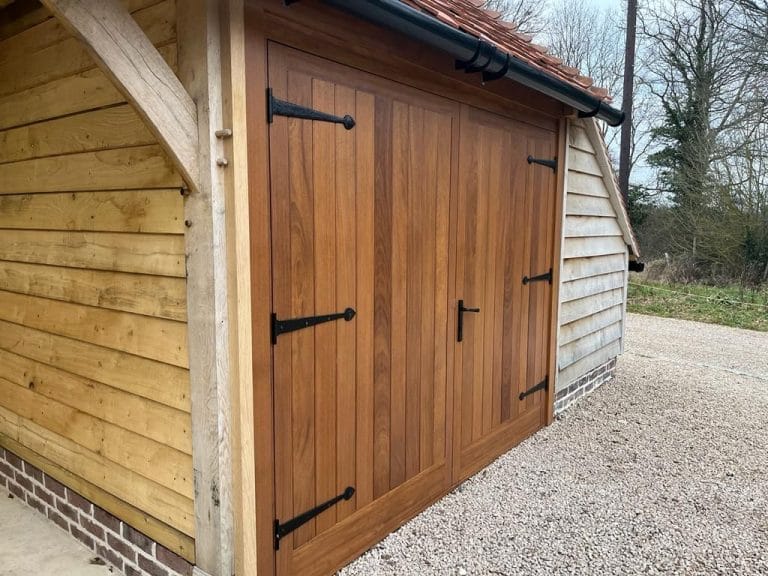 Close up of ledged timber garage doors with black ironmongery