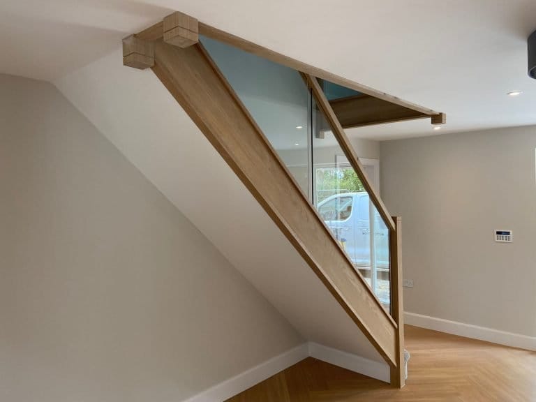 Timber staircase with glass balustrade panels, viewed from below
