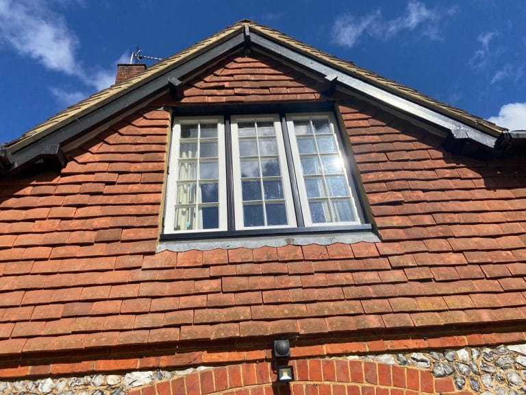White timber dormer windows in a clay tiled roof