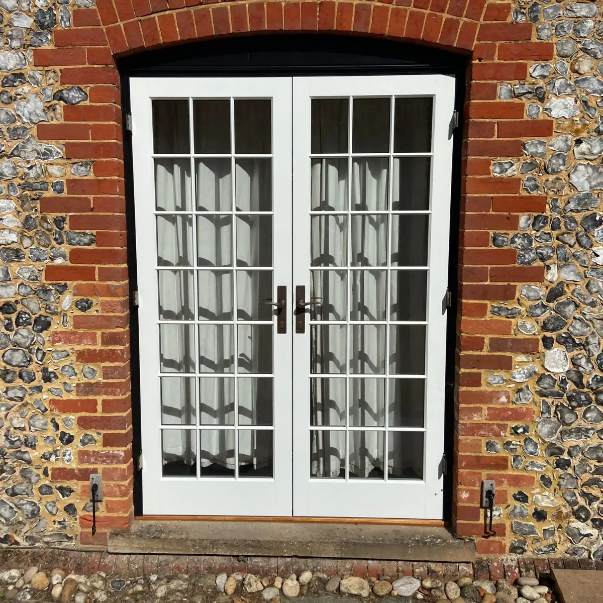 White timber French doors set into a brick wall, made by Spittlywood
